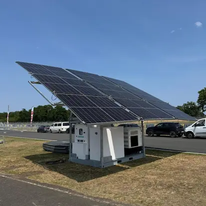 Station d'énergie hybride mobile Nexa Energy Africa avec panneaux solaires inclinés, unité de stockage par batterie et groupe électrogène sur un site événementiel.