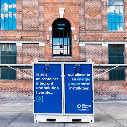 Container d'énergie propre Nexa Energy Africa intégrant une solution hybride de stockage et de production photovoltaïque devant un bâtiment industriel.
