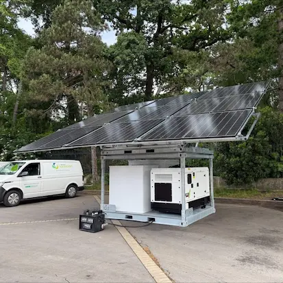 Groupe électrogène insonorisé Nexa Energy Africa couplé à une station de stockage d'énergie et des panneaux solaires photovoltaïques en extérieur.