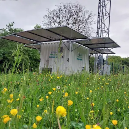 Container solaire mobile Nexa Energy Africa équipé de panneaux photovoltaïques déployables en plein champ pour l'alimentation d'un pylône de télécommunication.