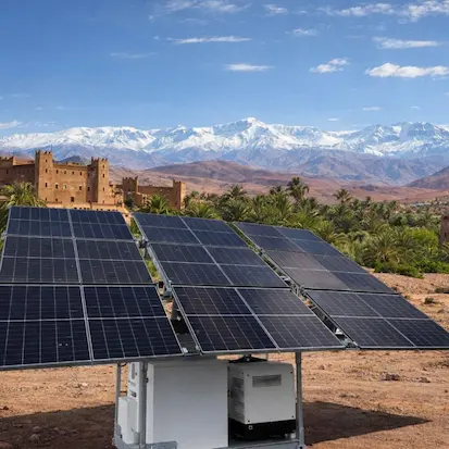 Groupe électrogène solaire mobile avec panneaux photovoltaïques et paysage montagneux.