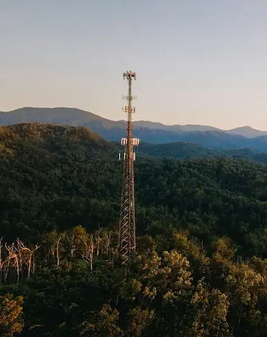 Tour de télécommunications isolée dans une forêt montagneuse, alimentée par les solutions d'énergie hybride de Nexa Energy Africa.